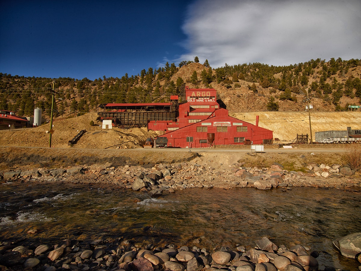 Argo Mine on the side of the Clear Creek tributary at low tide with mountains in the background