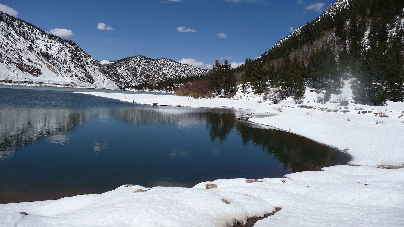 Georgetown Lake with snow on its banks and the mountains surrounding it